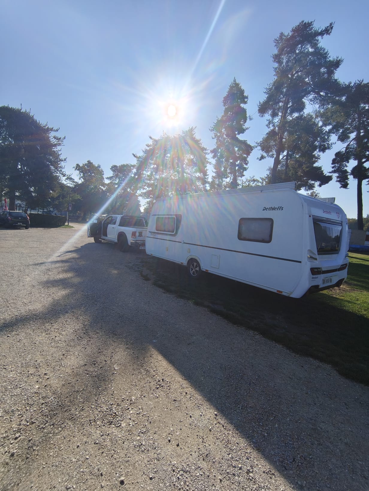 Wohnwagen mit Zugfahrzeug auf einem Parkplatz